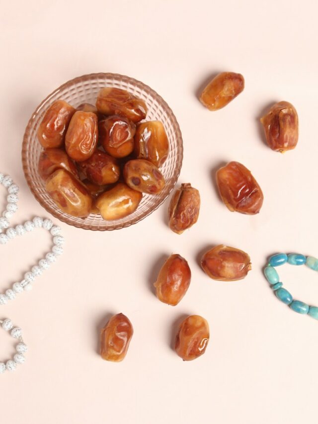 a glass bowl filled with nuts next to a beaded necklace