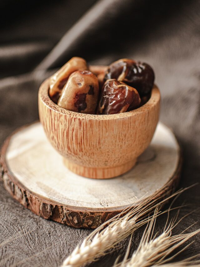 a wooden bowl filled with nuts on top of a wooden plate