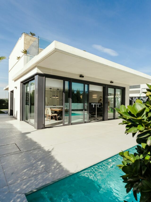 white and grey concrete building near swimming pool under clear sky during daytime