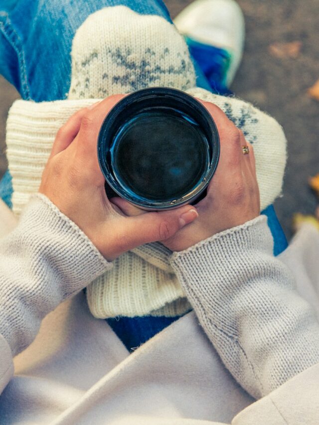 person holding black cup on top of person's lap