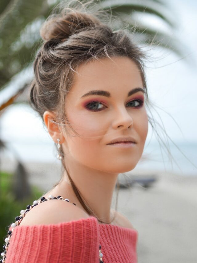 woman wearing red knit off-shoulder top looking sideways