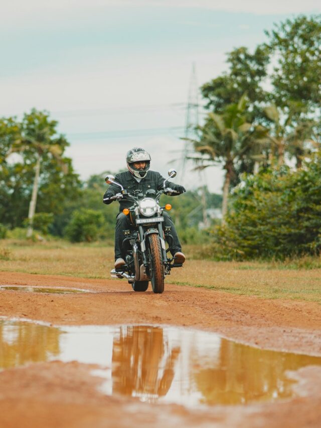 A man riding a motorcycle down a dirt road