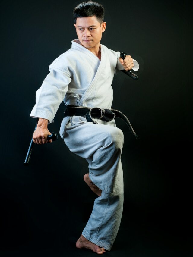 Black belt martial artist standing with one leg