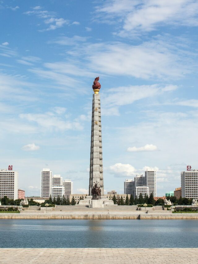 white and red tower near body of water during daytime