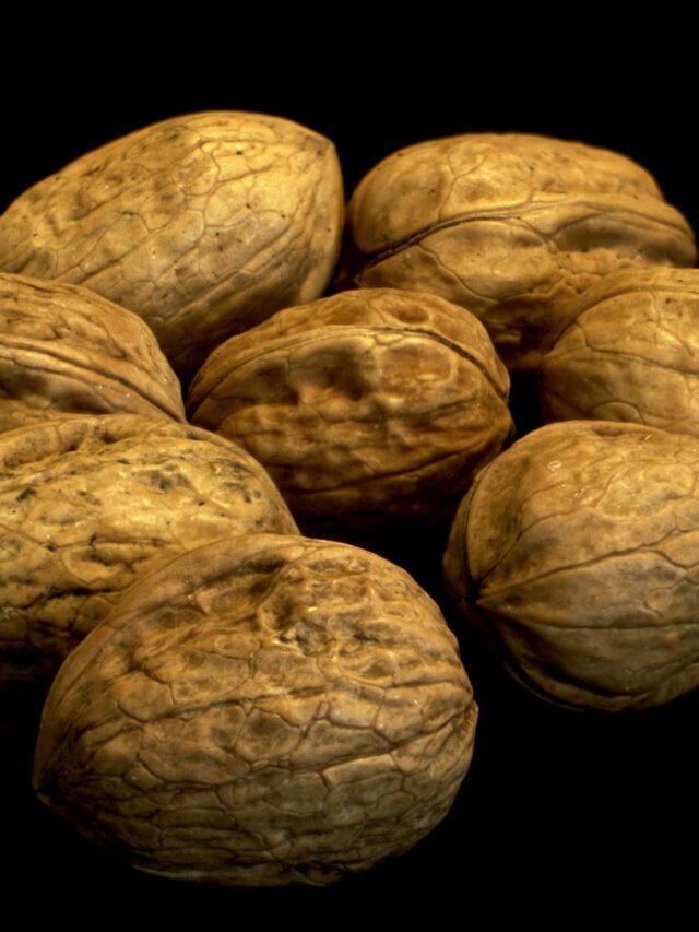 a pile of walnuts on a black background