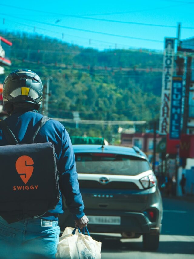 a person in a helmet and a backpack standing next to a car