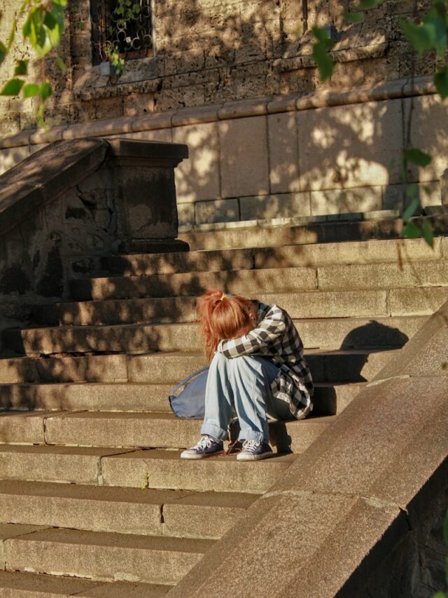 woman in black and white dress sitting on concrete stairs