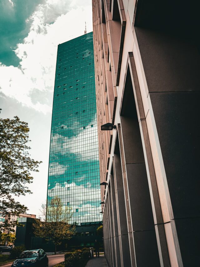 a tall building next to a street with a car parked in front of it