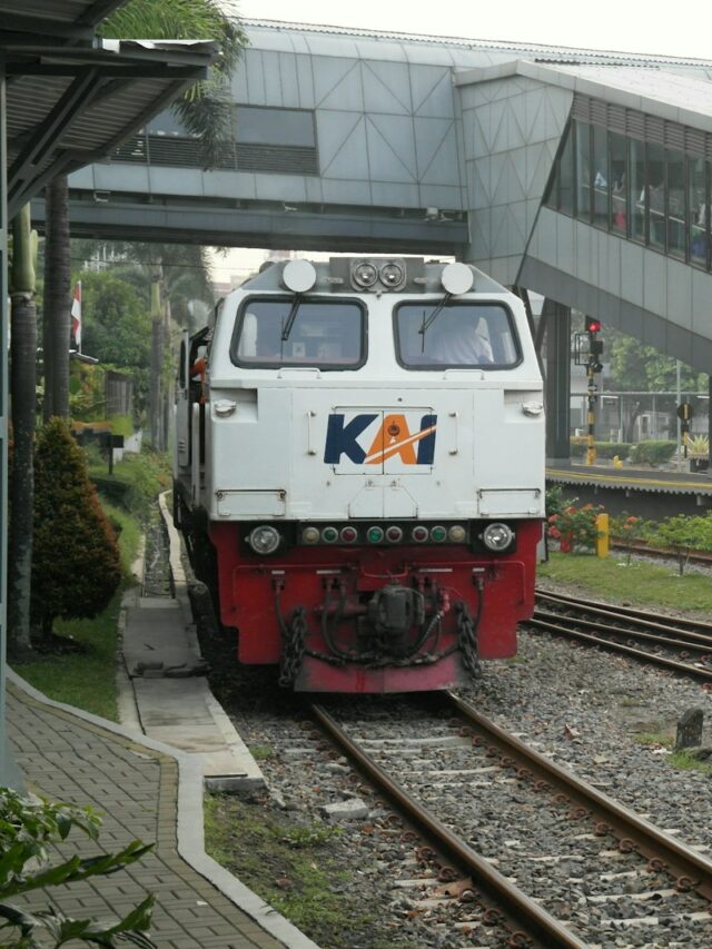 a train traveling down train tracks next to a building