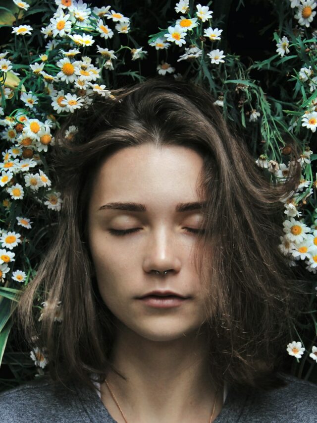 woman closing her eyes on white flower